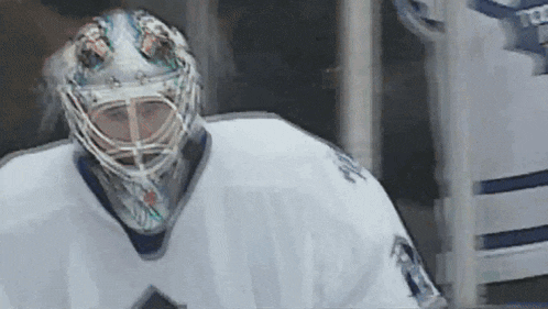 a hockey player wearing a white jersey with the number 20 on the back