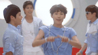 a group of young men in blue shirts are dancing