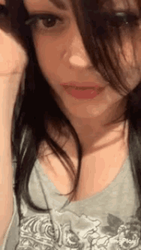 a close up of a woman 's face with a gray shirt on and red lipstick .