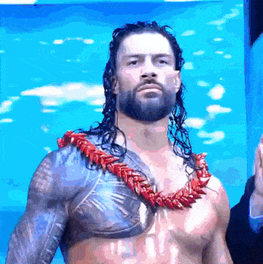 a wrestler with long hair and a red lei around his neck