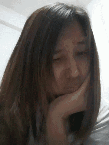 a close up of a woman 's face with her hand on her chin .