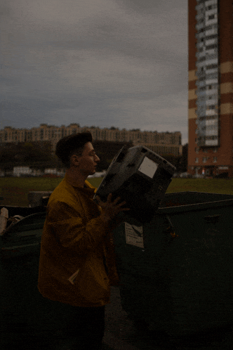 a man in a yellow jacket is carrying a box with a label that says ' a ' on it