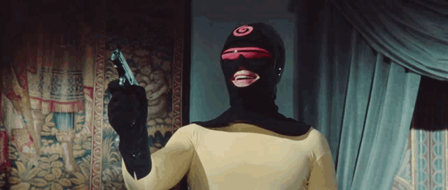a man wearing a mask and sunglasses holds a gun in his hand
