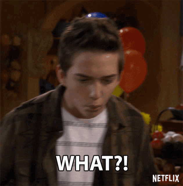 a man with balloons in the background says " what "