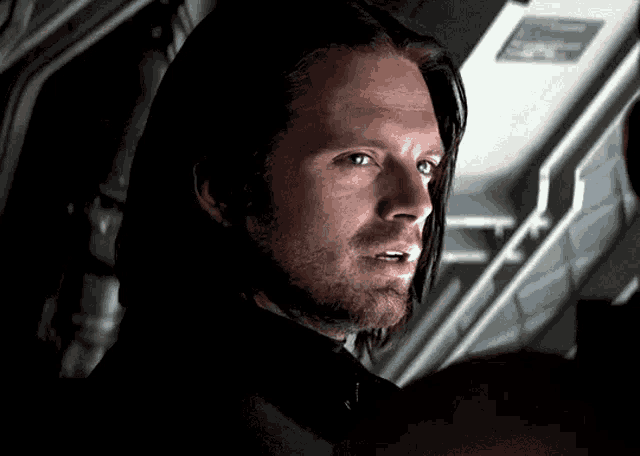 a close up of a man 's face with a beard and long hair