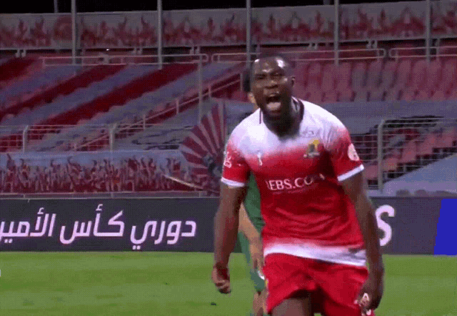 a soccer player in a red and white jersey with ebs.com on it