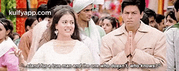 a man and a woman are standing next to each other in a crowd of people .