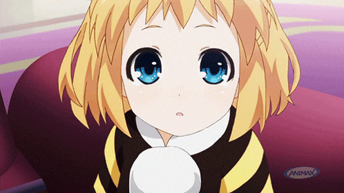 a little girl with blue eyes is sitting in front of an animax sign