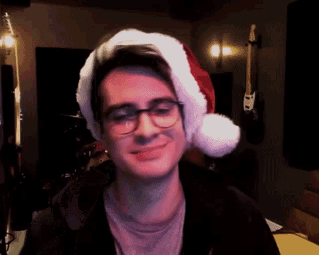 a young man wearing glasses and a santa hat