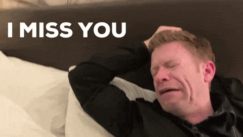 a man is laying on a bed with his eyes closed and the words i miss you above him