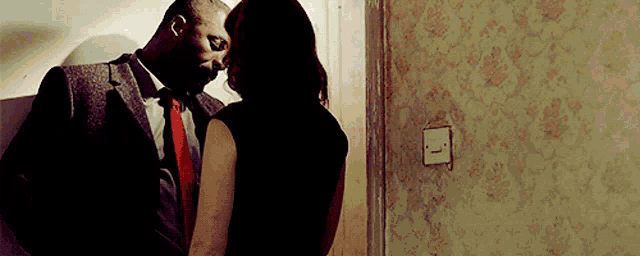 a man in a suit and tie is kissing a woman