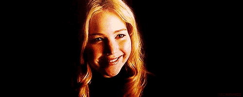 a close up of a woman 's face in a dark room with a black background .