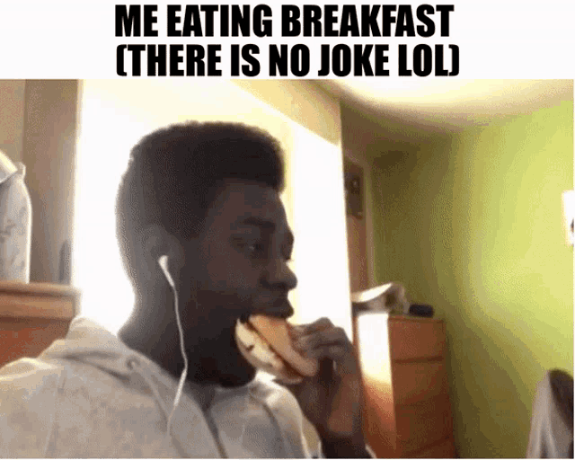 a man wearing ear buds eating a sandwich with the caption me eating breakfast there is no joke lol