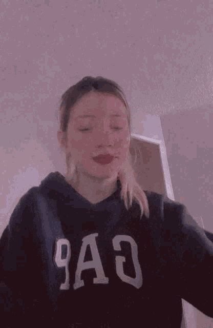 a girl wearing a gap sweatshirt is holding a fork in her hand