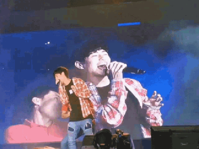 a man singing into a microphone with his mouth open