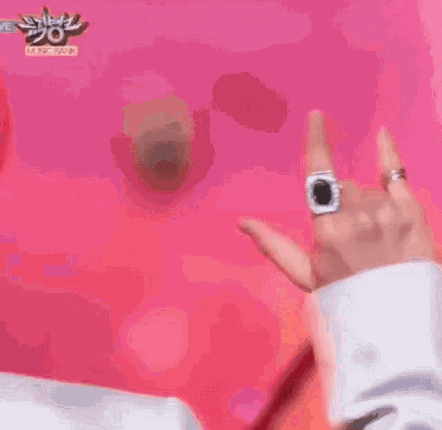 a man with red hair and a ring on his finger is making a devil horns sign .