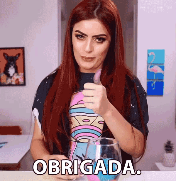 a woman with red hair is giving a thumbs up and the word obrigada is on the table