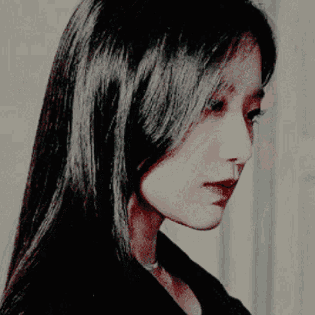 a woman with long black hair is looking down at something
