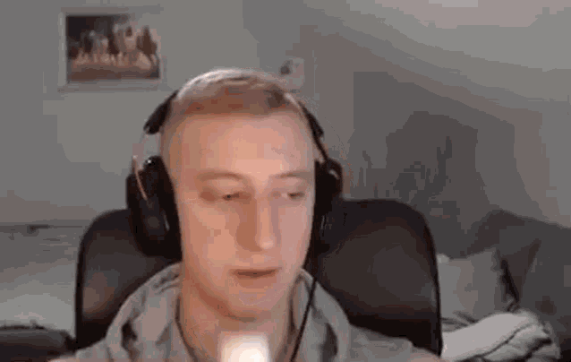 a man wearing headphones and a hoodie is sitting in a chair .