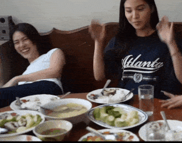 a woman wearing an atlanta shirt sits at a table