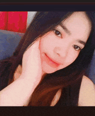 a close up of a woman 's face with a hand on her chin