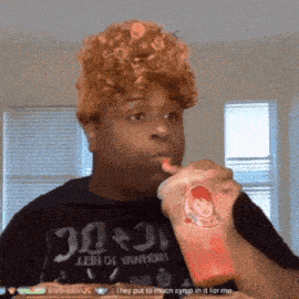 a man drinking from a wendy 's cup while wearing a wig