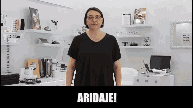 a woman wearing glasses is standing in front of a sign that says aridaje