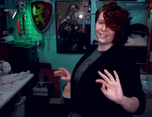 a woman with red hair is smiling and giving the peace sign
