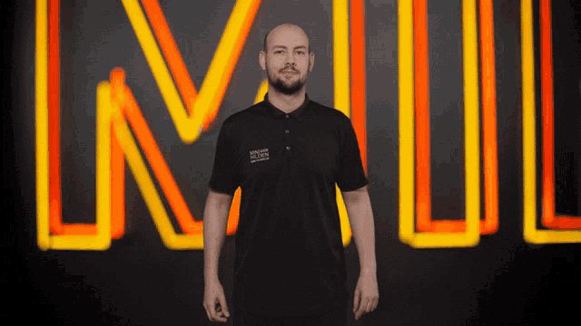 a man stands in front of a neon sign that says ln on it