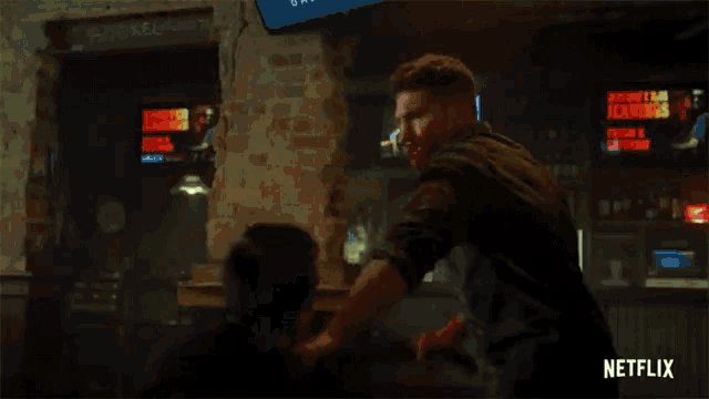 a man is being hit in the face by another man in a dark room .
