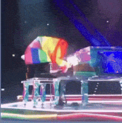 a person playing a piano with a rainbow flag on it