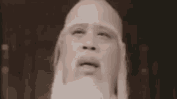 a bald man with a beard is making a funny face and says `` sure '' .