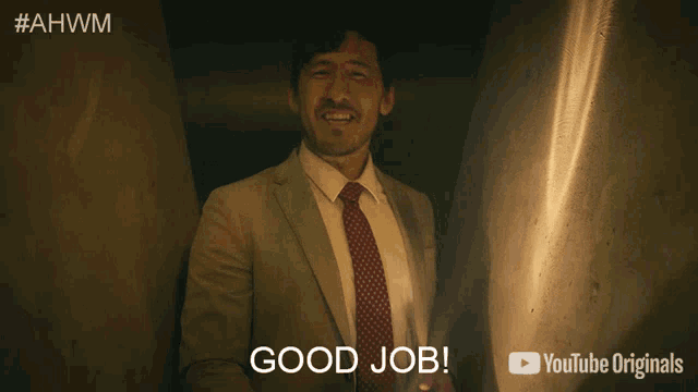 a man in a suit and tie with his eyes closed says good job