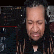 a man with dreadlocks is wearing headphones and crying while playing a video game