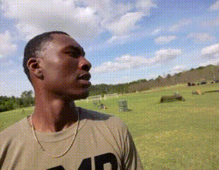 a man wearing a t-shirt with the number 40 on it is standing in a field