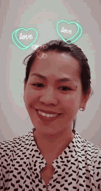 a woman wearing a polka dot shirt is smiling with hearts that say love on them