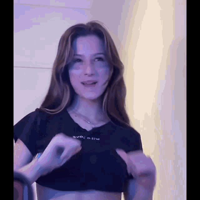 a young woman wearing a black crop top with the word evo on it
