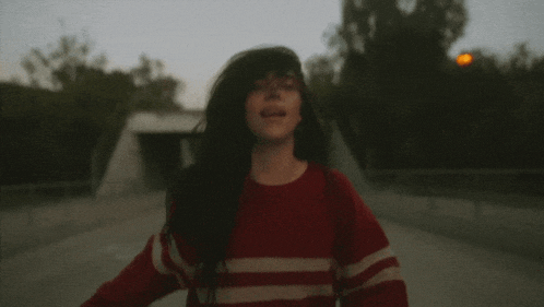 a man wearing a red and white striped sweater looks up at the sky