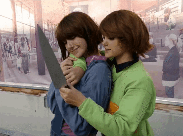 two girls are hugging each other and one is holding a knife in her hand