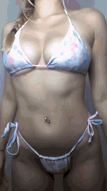a woman in a bikini has a belly button ring