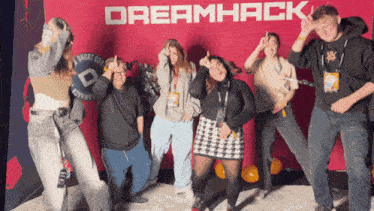 a group of people posing for a picture in front of a wall that says dreamhack