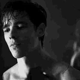a black and white photo of a shirtless man .