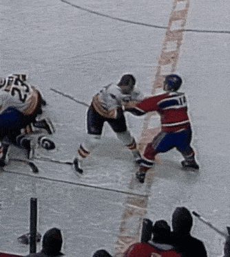 a hockey player with the number 12 on his back is fighting another player