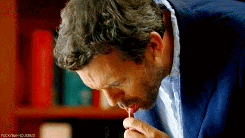 a man in a blue suit is licking a lollipop with the hashtag fuckyeahhousevid written below him