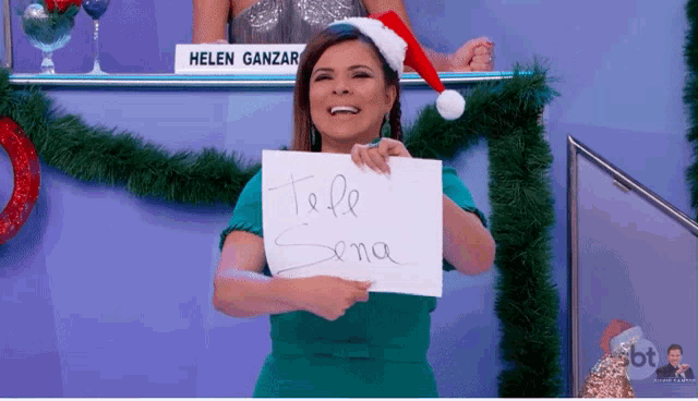 a woman in a santa hat holds a sign that says tele sena