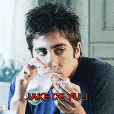 a man drinking a glass of milk and eating a donut with the name jake de yuli written below him