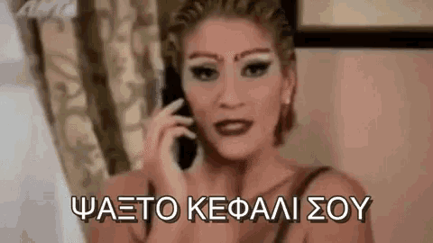 a woman is talking on a cell phone in a room with greek writing .