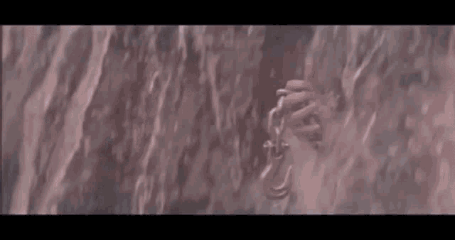 a close up of a person climbing up a cliff .
