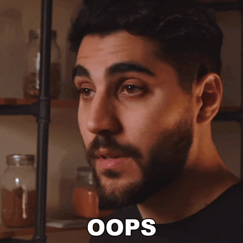 a man with a beard has the word oops on his shirt