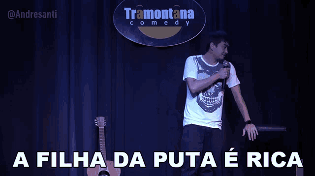 a man singing into a microphone in front of a tramonto comedy sign